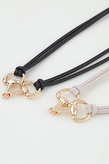 Close-up of the polished horsebit toggle clasp and knotted rope detail