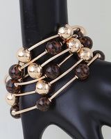 Leopard and gold bead bangle set worn stacked on a display hand