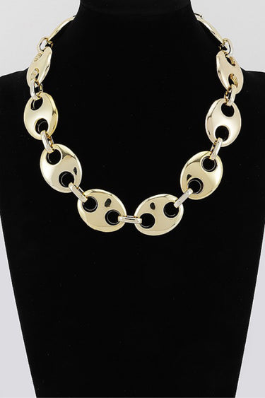 Gold oval link statement necklace on display bust