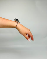 Polished silver cuff bracelet featuring two spheres