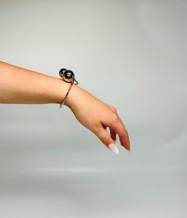 Polished silver cuff bracelet featuring two spheres