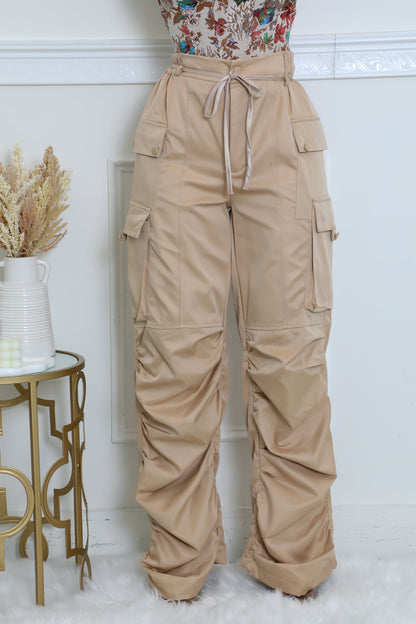 Comfortable beige utility pants with unique ruching and functional pockets, ideal for casual and chic outfits.