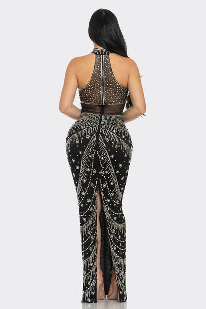 Long black formal gown with crystal embellishments and elegant detailing.
