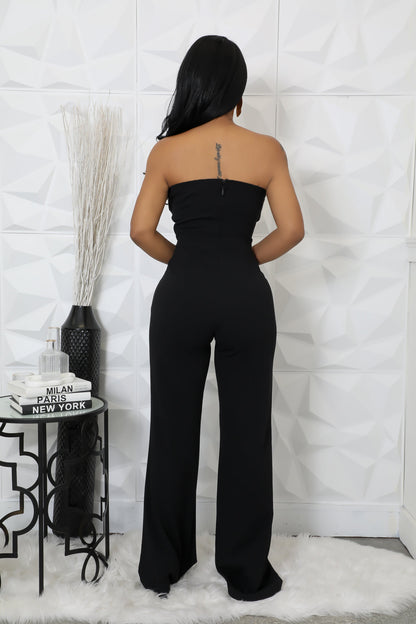 Modern black jumpsuit with wide-leg pants and asymmetrical top.
