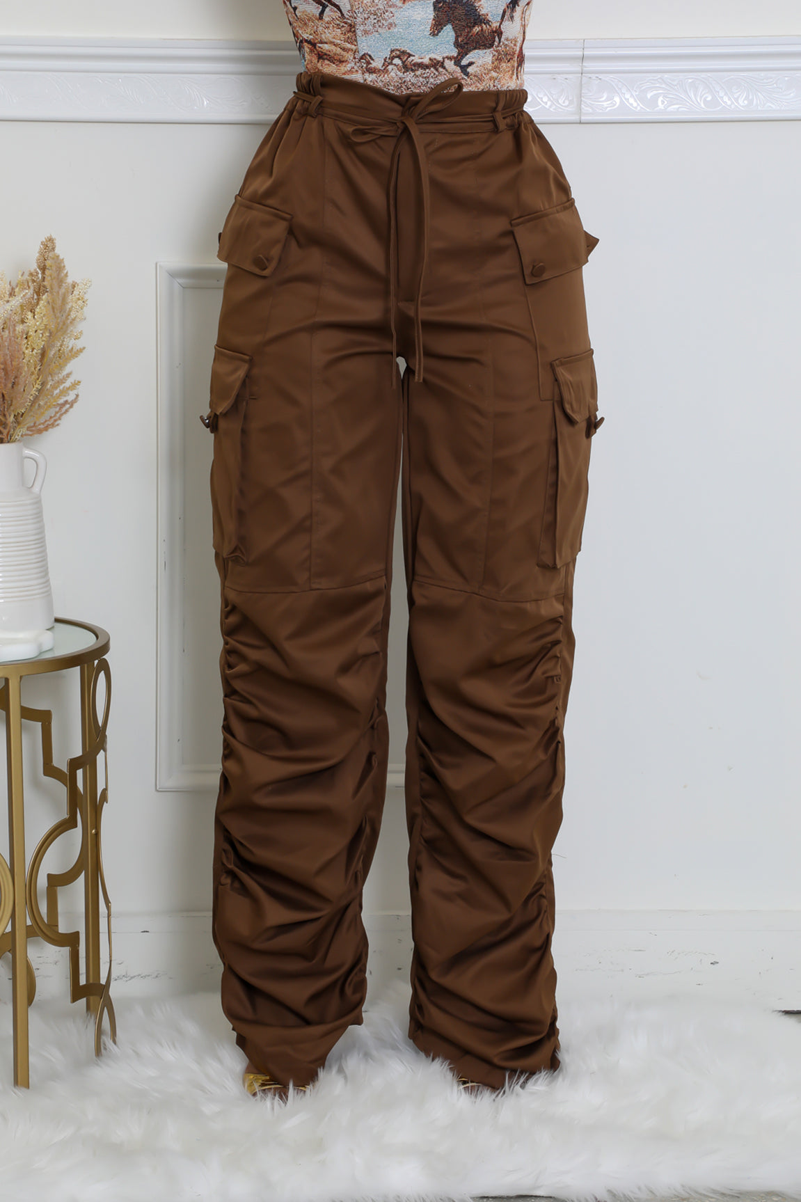 Trendy women's brown cargo pants with multiple functional pockets.