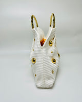 Minimalist white woven tote with golden accent spheres