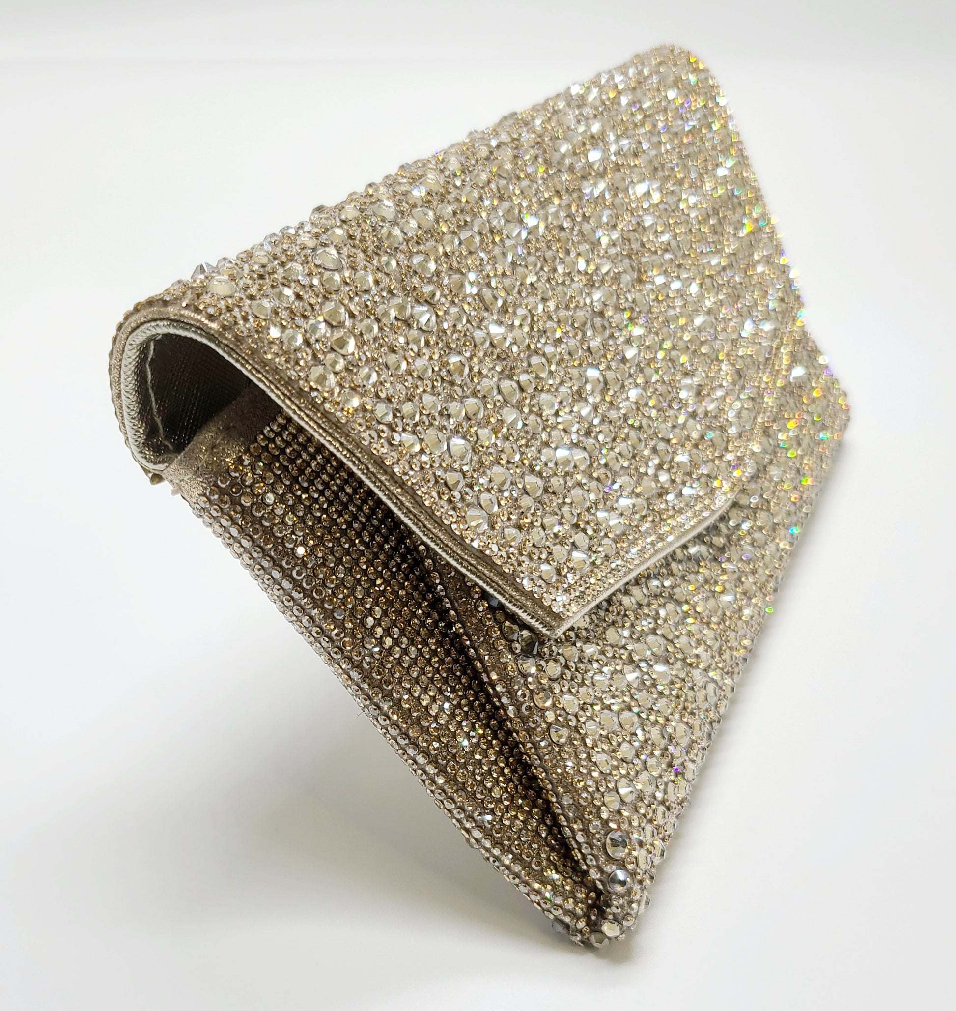 Close-up view of a gold crystal clutch showcasing its intricate rhinestone details.
