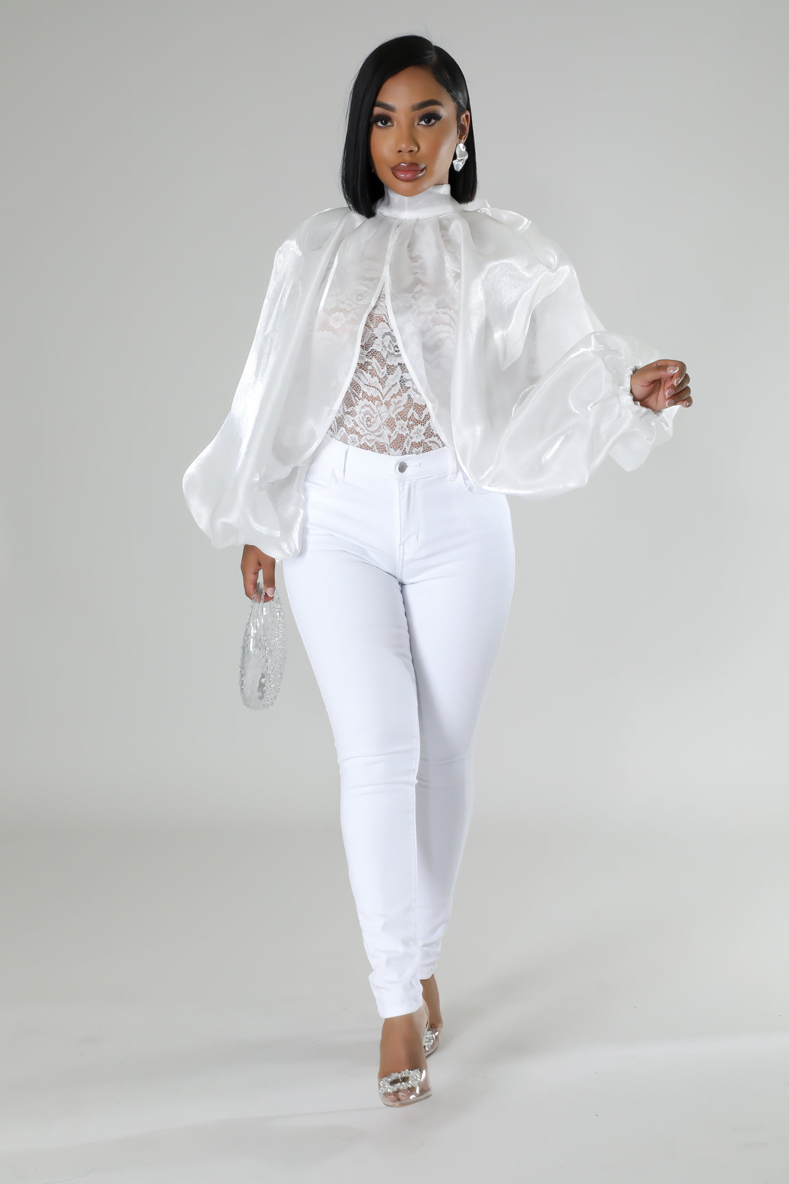 High-waisted white jeans with a sheer organza and lace blouse