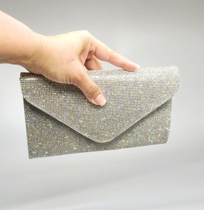 Silver handbag featuring a structured envelope closure and sparkling rhinestones.
