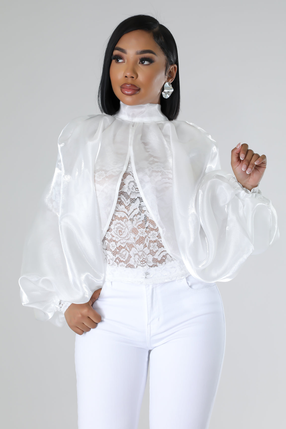 White organza blouse with lace details and high-waisted white jeans