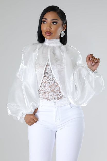 White organza blouse with lace details and high-waisted white jeans