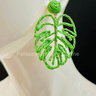 Green statement earrings with tropical leaf design