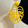 Yellow statement earrings with tropical leaf design