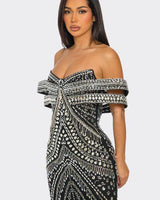 Woman wearing black rhinestone mini dress with off-shoulder neckline