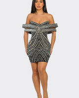 Woman wearing black rhinestone mini dress with off-shoulder neckline