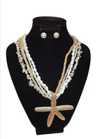 White gold layered ocean charm necklace with starfish and shell design – statement piece