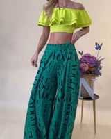 Green wide leg palazzo pants with allover Vogue-inspired graphic design