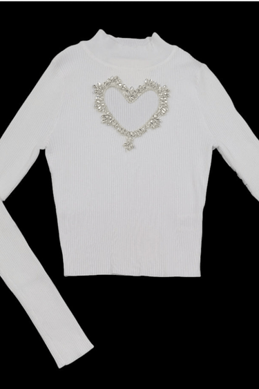 Ribbed white turtleneck with bold heart-shaped detail