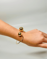 Gold cuff bracelet – polished open‑cuff design with spherical ends