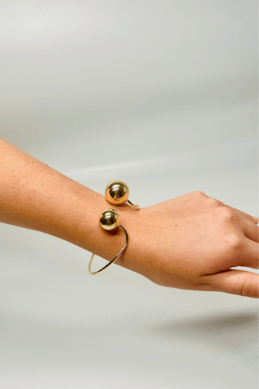 Gold cuff bracelet – polished open‑cuff design with spherical ends