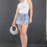 Shiny blue skort styled with white tank top and silver heels