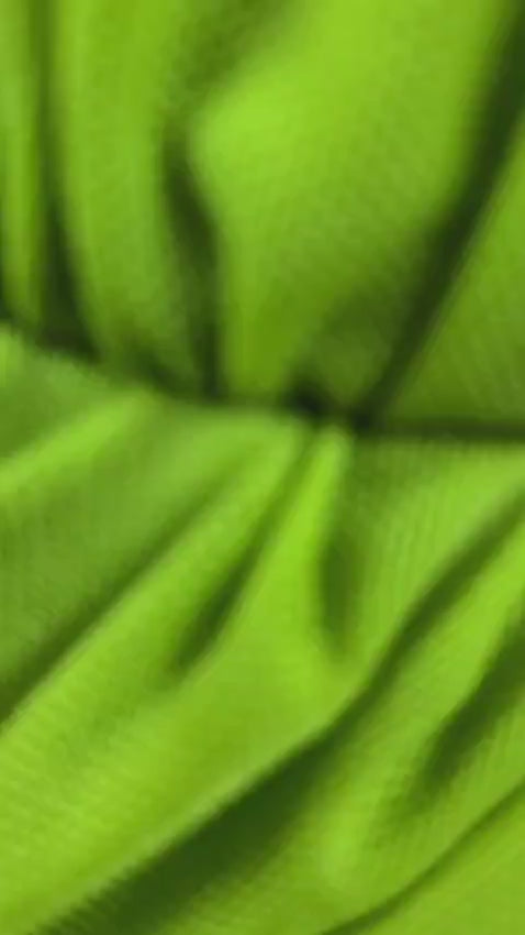 Draped mini dress in vibrant green with gathered waist and soft fabric.
