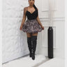 Front view of leopard print bubble mini skirt styled with black top and thigh-high boots
