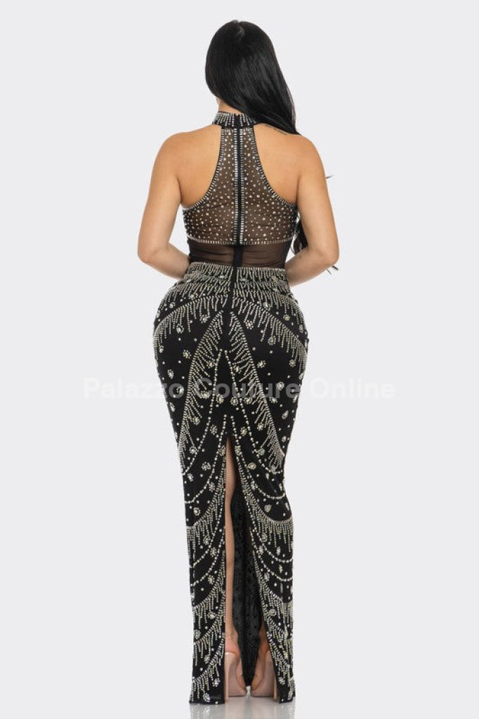 Long black formal gown with crystal embellishments and elegant detailing.
