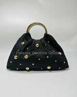 Black woven straw tote bag with gold accents and circular handles