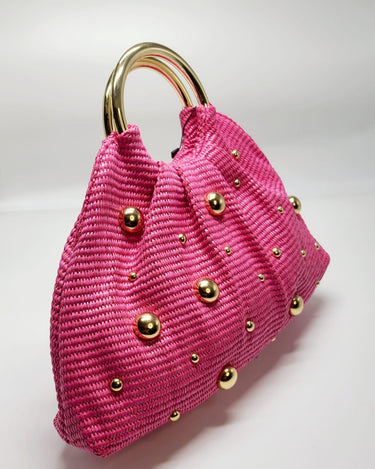 Close‑up of soft woven tote bag showing woven detail and gold handle in fuchsia