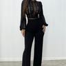 Elegant black jumpsuit with intricate lace detailing on the bodice, sheer sleeves, and a flattering wide-leg silhouette.